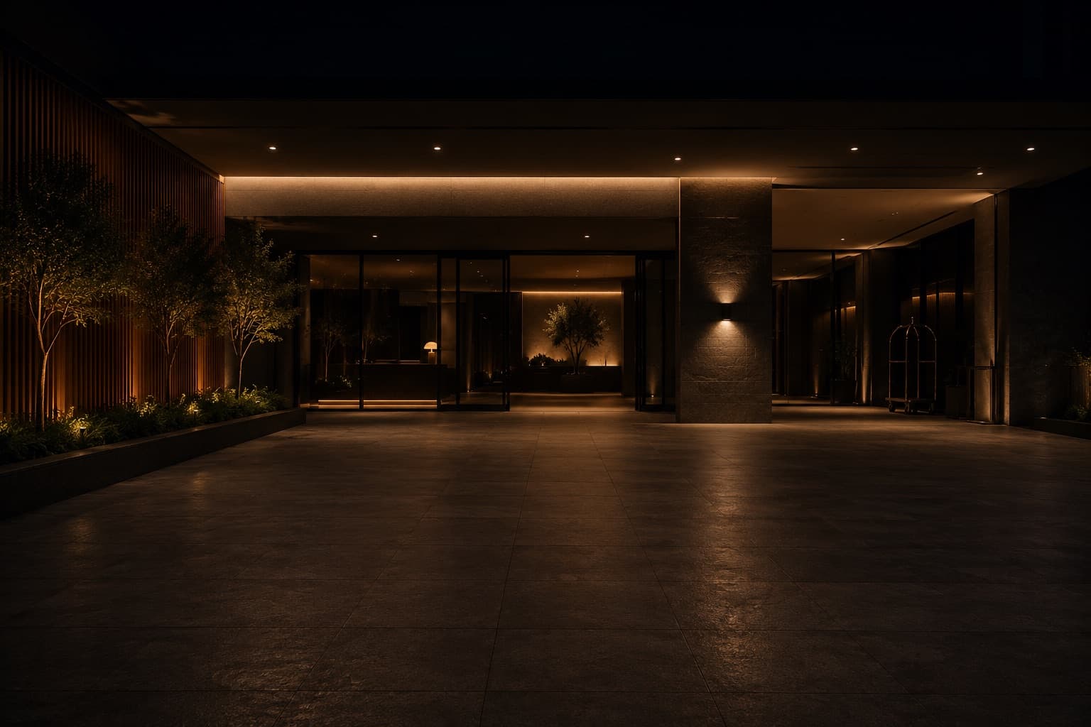 Entrada de un hotel de noche, con la recepción iluminada al fondo